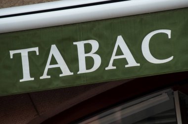 closeup of green tabacco store front with french text tabac, the traduction in english of tobacco  clipart