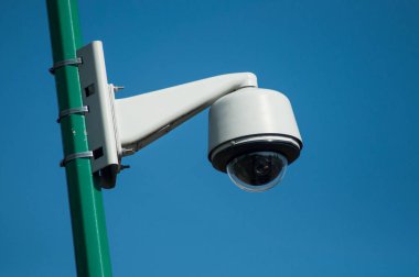 Mavi gökyüzü arka planındaki güvenlik kamerasının yakın plan görüntüsü