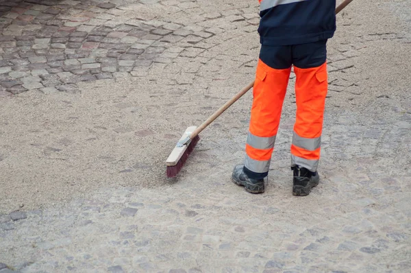 retail of worker legs on cobblestone maintenance site on main place