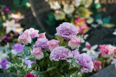 Mezarlıktaki mezardaki yapay çiçeklerin yakın çekimi.