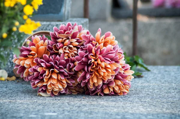 Closeup umělých květin na hrob na hřbitově — Stock fotografie