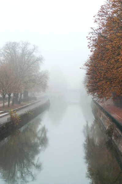 panorama of Mulhouse in Alsace with picturesque channel by autumn with fog