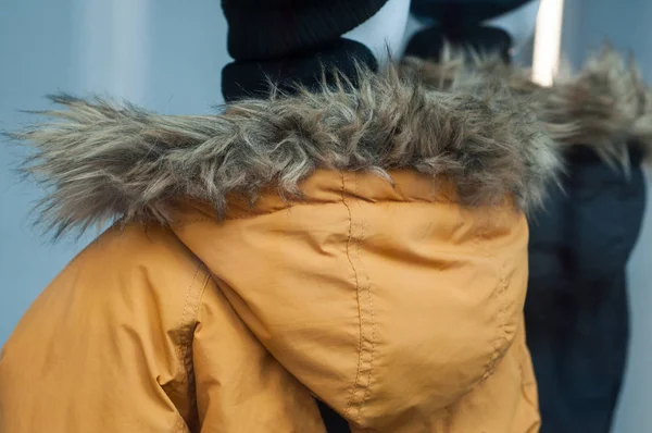 ファッションでマネキンに毛皮フード付き黄色の冬のコートのクローズ アップ ストア ショールーム — ストック写真
