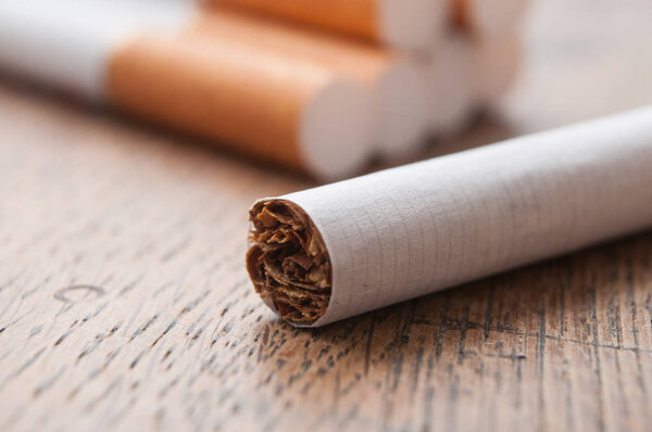 Closeup of cigarettes on wooden table background
