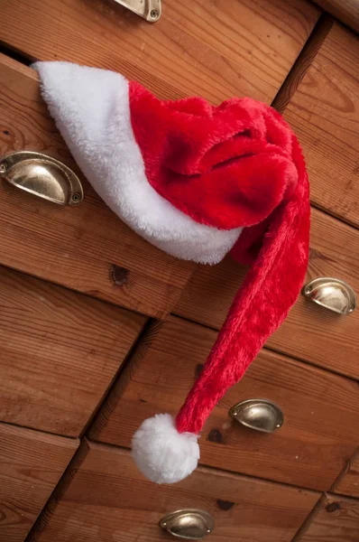 木製のたんすの背景にクリスマス帽子のクローズ アップ — ストック写真