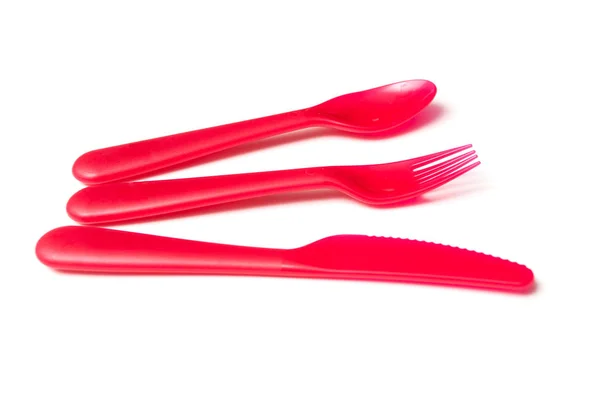 一套红色的婴儿塑料勺子 叉子和刀在白色背景 — 图库照片