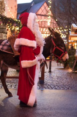 Eguisheim - Fransa - 20 Aralık 2018 - Noel Baba kostüm ve eşek adam portresi, Noel pazarı 