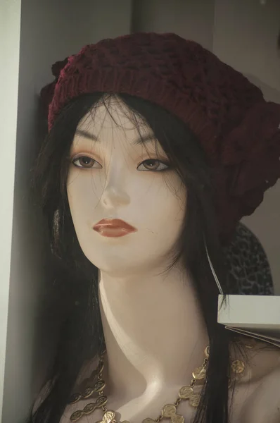 在时装店陈列室用假发和羊毛帽子的人体模型的女人脸特写镜头 — 图库照片