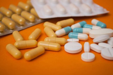 tatlı turuncu zemin üzerine ilaç tablet ve kapsül