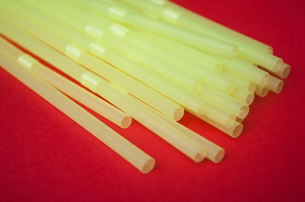 Closeup Yellow Plastic Straw Collection Red Background — Stock Photo, Image
