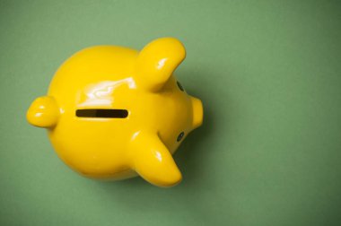 üstten görünüm üzerinde yeşil zemin üzerine sarı kumbara closeup