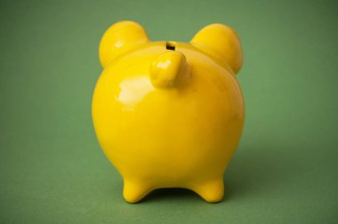 Arkadan görünüm üzerinde yeşil zemin üzerine sarı kumbara closeup