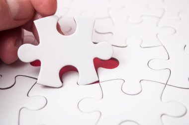 Görevi tamamlamak için adam eliyle bilmecenin son parçası kırmızı zemin üzerine koyarak.