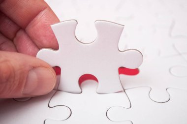 Görevi tamamlamak için adam eliyle bilmecenin son parçası kırmızı zemin üzerine koyarak.