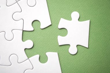 yeşil arka plan üzerinde görevi tamamlamak için eksik yapboz son parçası closeup