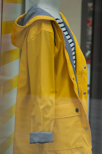 closeup of yellow rain coat in fashion store showroom