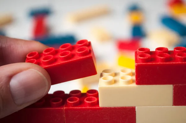 Close Mão Homem Brincando Com Construção Tijolos Plástico Fundo Branco — Fotografia de Stock