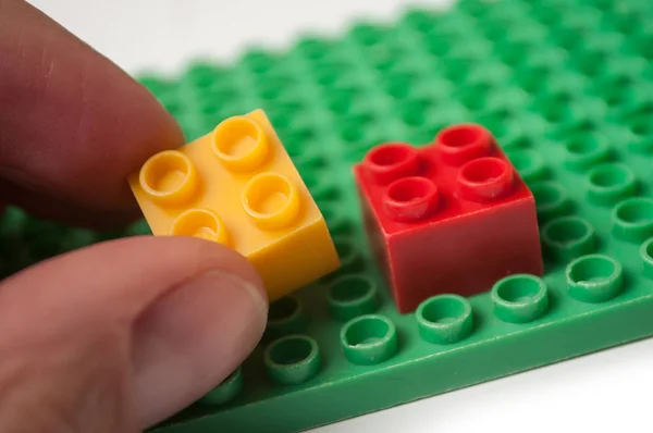 Close Mão Homem Brincando Com Construção Tijolos Plástico Fundo Branco — Fotografia de Stock