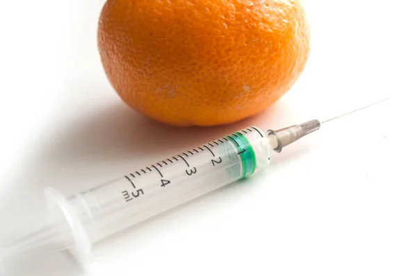 Gros plan de l'injection avec une seringue dans une mandarine sur ba blanc — Photo