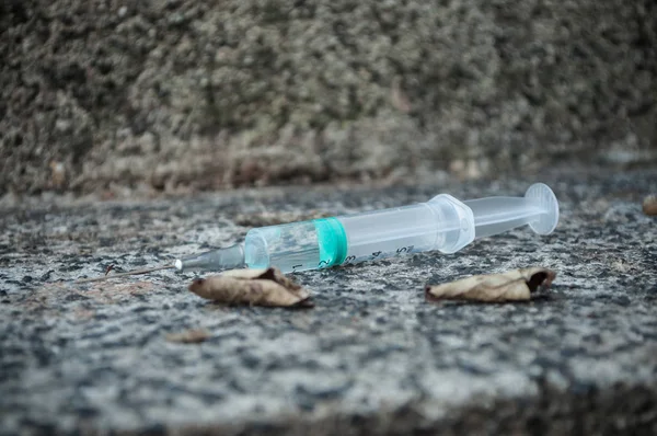 Closeup of syringue abandoned on the floor in the street — Stock Photo, Image