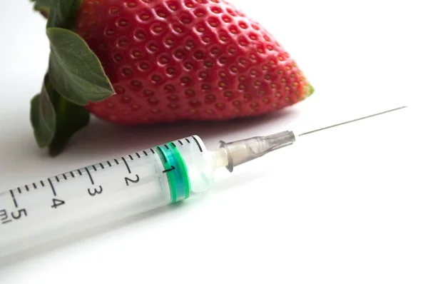 Gros plan de l'injection avec une seringue dans une fraise sur blanc b — Photo