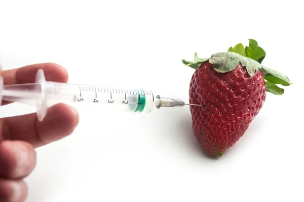 Detailní záběr na rukou člověka injekční stříkačkou do jahodo — Stock fotografie