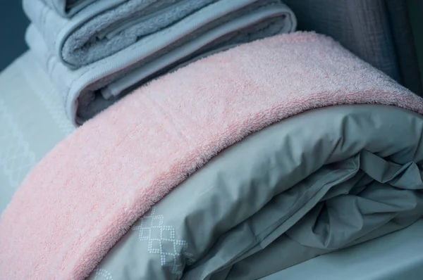 Primer plano de la pila de toallas de baño grises en la cama en el espectáculo de la tienda de decoración — Foto de Stock