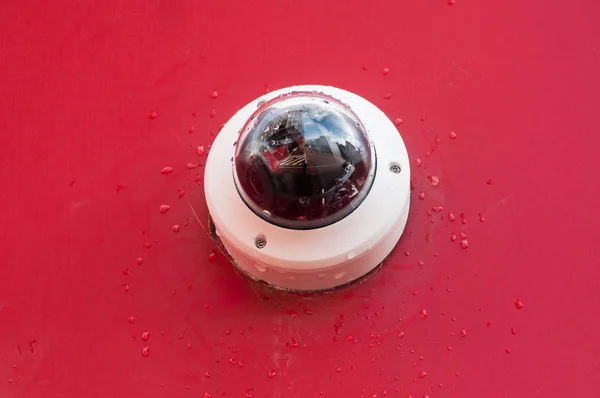 Nahaufnahme einer Überwachungskamera auf rotem Wandhintergrund — Stockfoto