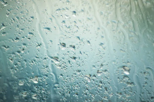 Closeup of rain drops on windscreen of car  on cloudy sky backg — Stock Photo, Image