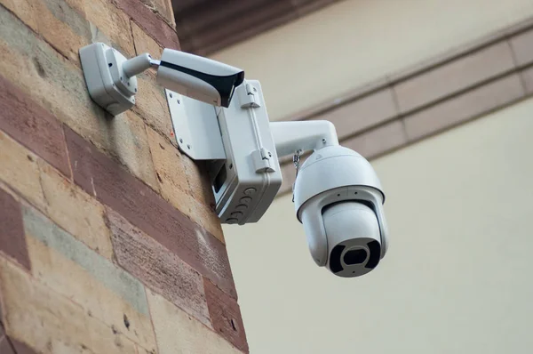 Close-up van witte beveiligingscamera van veiligheid op gestenigd muur — Stockfoto