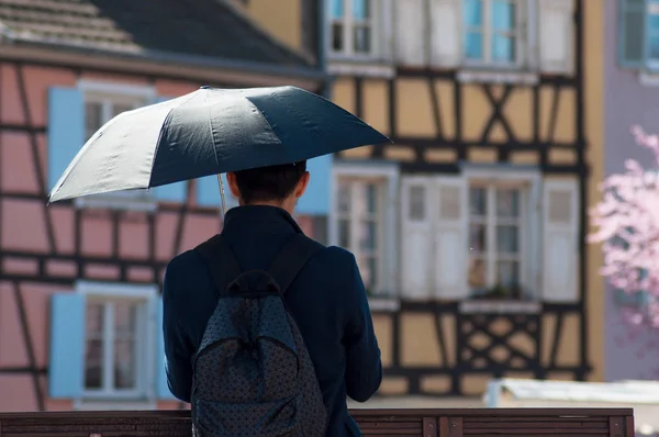 Asian tourist with umbrella  taking a picture on bridge — Stock Photo, Image