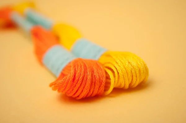Closeup of colorful cotton threads on yellow background — Stock Photo, Image