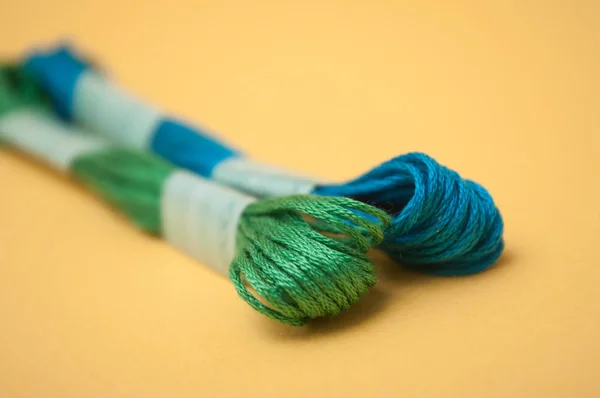 Closeup of colorful cotton threads on yellow background — Stock Photo, Image