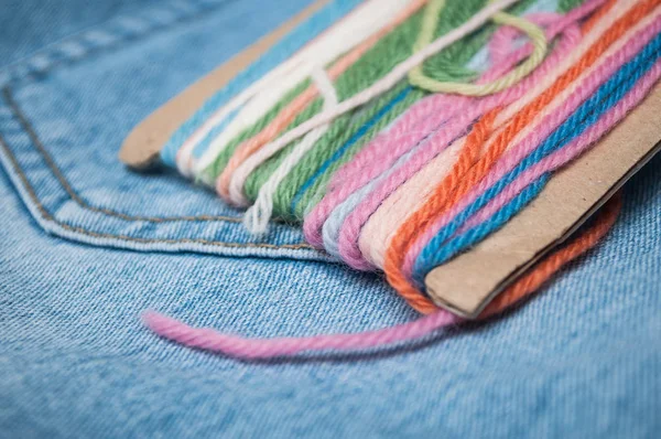 Zbliżenie, kolorowe wełnianych nici na tle niebieski jeans — Zdjęcie stockowe