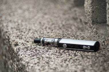 Taşlı arka planda gri elektronik sigaranın kapatılması 