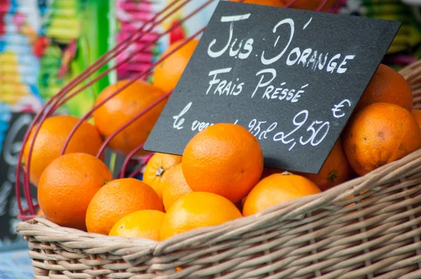 Zbliżenie organicznych pomarańczy w drewnianym koszyku na rynku — Zdjęcie stockowe