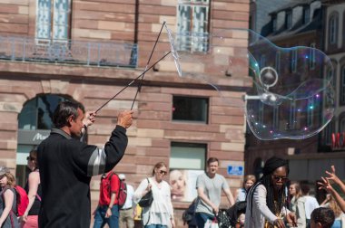 Strazburg Kleber yerde sabun kabarcıkları ile oynayan adam