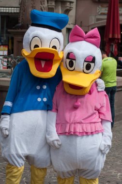 Donald Duck ve papatya kostümü olan insanlar