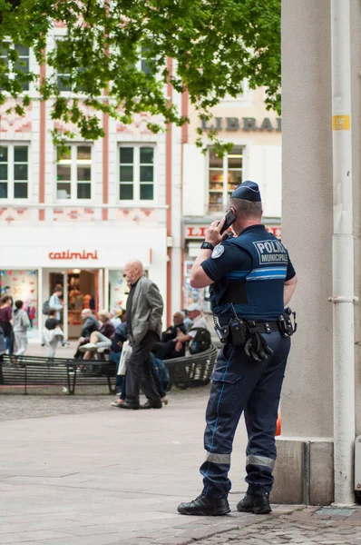 フランスの自治体の警官が電話を手にして主要な場所に立っている — ストック写真