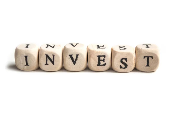 Concept woord op houten kubus op witte achtergrond-Invest — Stockfoto