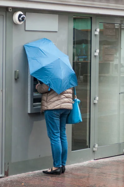 Γυναίκα με ομπρέλα στην αυτόματη τράπεζα της πόλης — Φωτογραφία Αρχείου