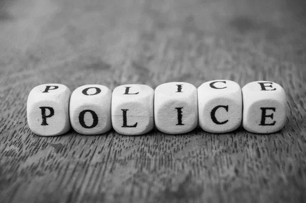 Closeup of word on wooden cube on wooden desk background concept - Police — Stock Photo, Image