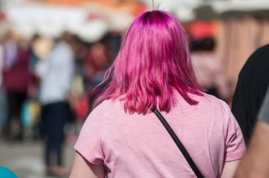 sokakta yürüyen pembe saçlı kadının yakın çekim 
