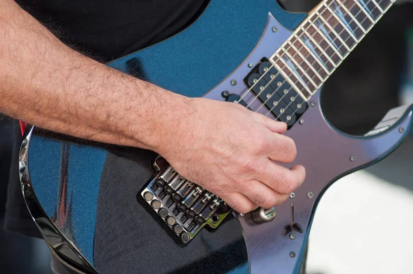 Close-up de mão do músico na guitarra elétrica no exterior — Fotografia de Stock