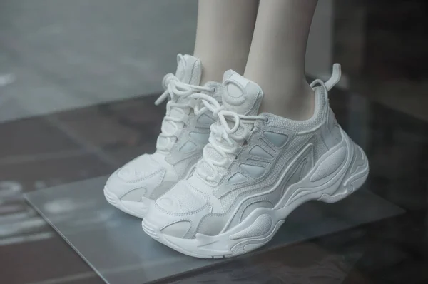 Крупный план белых кроссовок на манекене в салоне модного магазина — стоковое фото