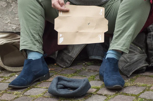 homeless woman man begging with cardboard  in the street