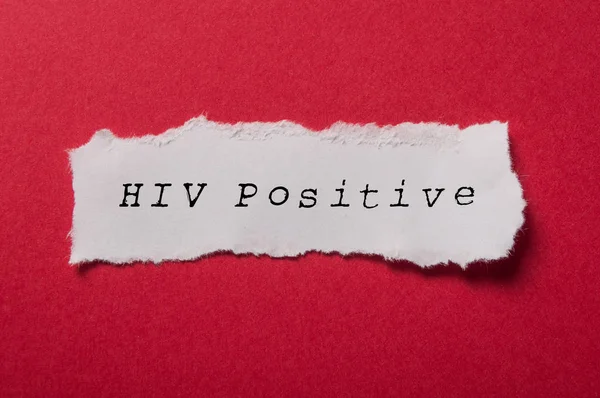 Vitt rivnings papper på rött papper bakgrund-hiv-positiv — Stockfoto