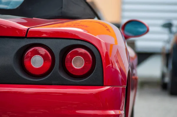 Primo piano della luce posteriore di rosso ferrari parcheggiata in strada — Foto Stock