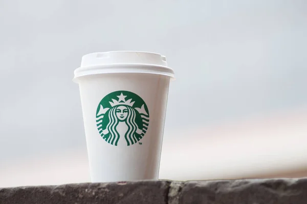 Білі забирають чашку на свіжому повітрі від бренду Starbuck — стокове фото