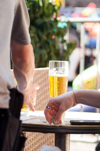 Mann bezahlt Bier auf Restaurantterrasse — Stockfoto